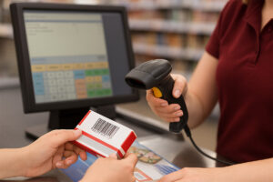 Kasada ürün barkodunu okuyan kasiyer ve POS ekranı